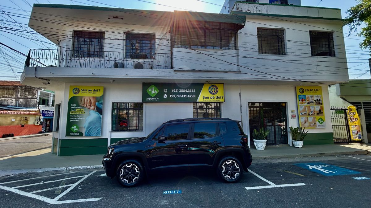 Fachada da All Pé Vieiralves, com a placa verde da clínica e estacionamento na frente